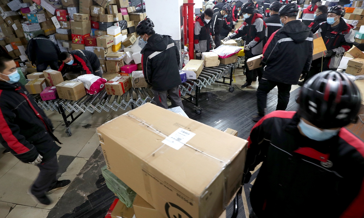 Delivery men from SF Express sort parcels at a branch in Beijing on November 12, 2021. Data from the State Post Bureau showed that from November 1 to 11, postal and express delivery companies across the country handled 4.77 billion parcels, a year-on-year increase of more than 20 percent. Among them, 696 million express parcels were processed on November 11, a new high. Photo: cnsphoto