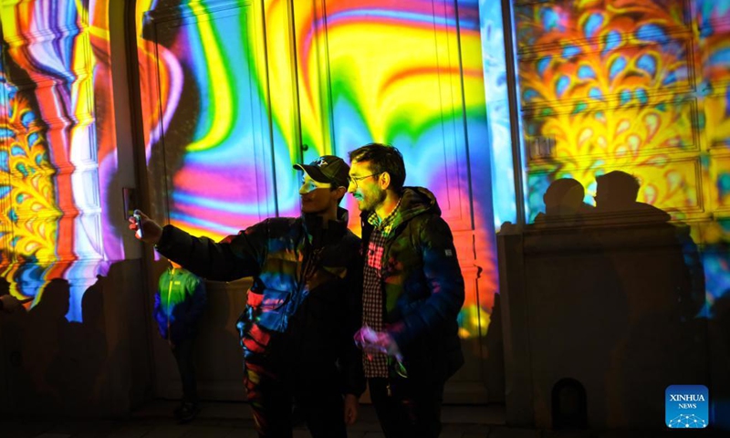 People take a selfie at the Ghent Light Festival 2021 in Ghent, Belgium, Nov 11, 2021. From Nov. 10 to 14, over 30 works by international light artists are offered to the public at the Ghent Light Festival 2021, which is held every three years. Photo:Xinhua