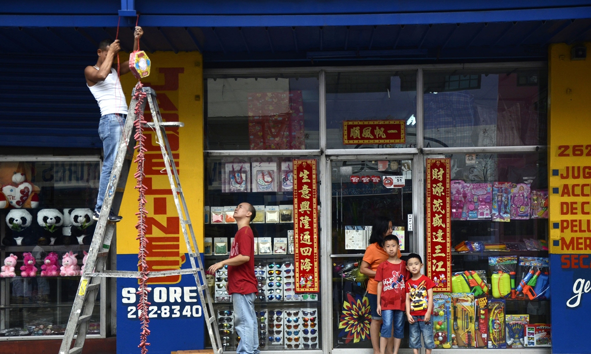 Members of a family hang firecrackers in front of their shop during a Chinese New Year, or Spring Festival parade in Chinatown in Panama City on February 8, 2016. That year the Chinese community celebrates the Year of the Monkey. Photo: VCG