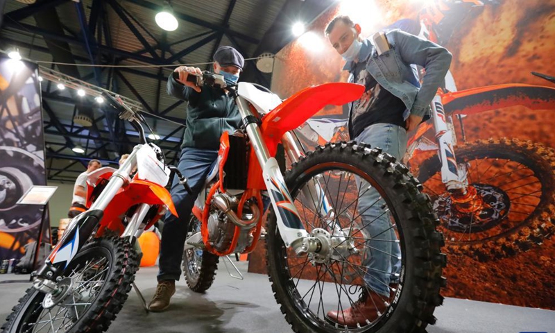 People check an off-road motorcycle during a travel vehicles exhibition in Moscow, Russia, Nov. 14, 2021.Photo:Xinhua