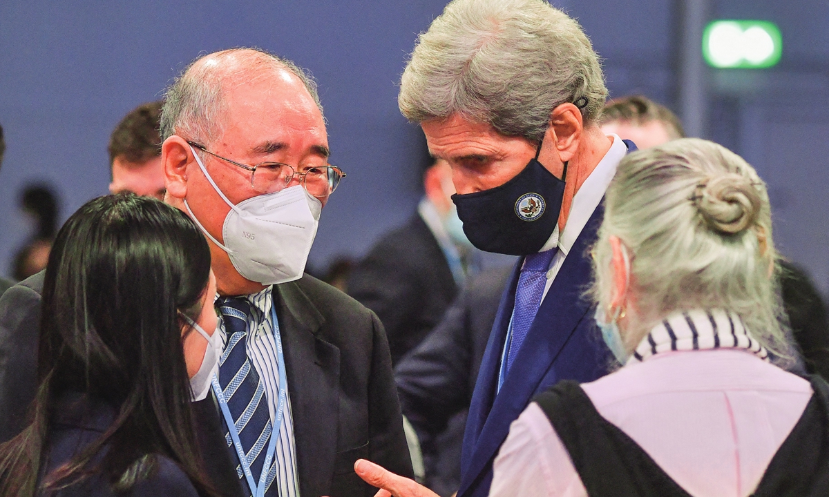 Xie Zhenhua (left), China's special envoy for climate change, speaks with John Kerry, US special presidential envoy for climate, during the COP26 on November 13, 2021. Photo: AFP