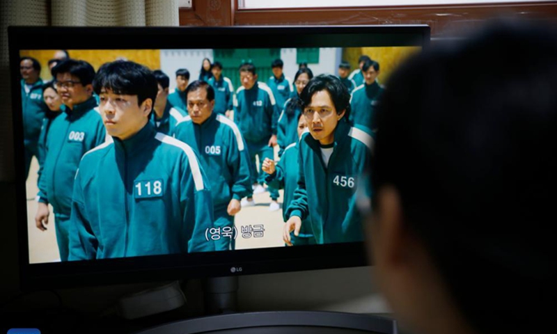 A person watches the South Korean drama Squid Game at home in Seoul, South Korea, Nov. 15, 2021. The South Korean drama Squid Game has drawn worldwide attention as it vividly depicts the cruelty of capitalistic society through children's games played by a group of debt-ridden underdogs for money. Photo: Xinhua