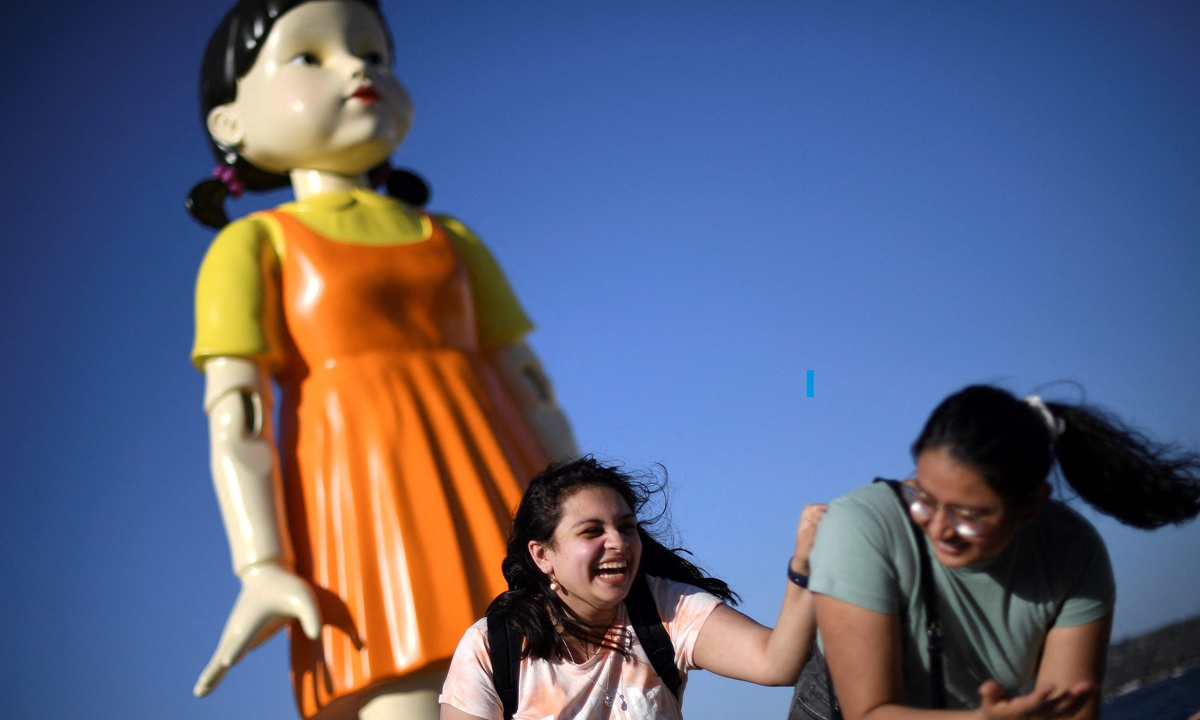 People visit a 4.5-meter-tall replica doll from the Netflix series <em>Squid Game</em> on display at the harbor in Sydney on October 29. Photo: VCG