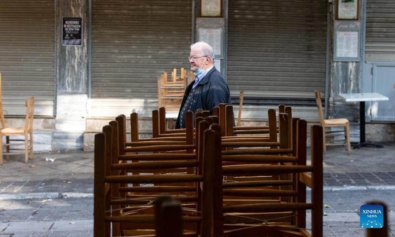 A man walks past a closed restaurant in Athens, Greece, on Nov. 16, 2021. Restaurants and cafes across Greece remained closed on Tuesday while a demonstration was held in Athens demanding further state support under the new COVID-19 restrictions introduced by the government this autumn to tackle the latest surge in infection rates.  (Xinhua)