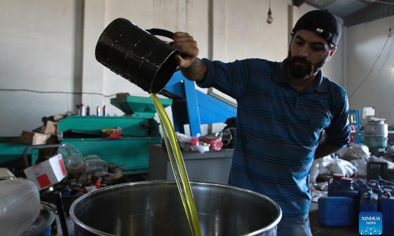 A worker checks the quality during the process of extracting olive oil in Koura, north Lebanon, on Nov. 16, 2021. (Photo by Khaled/Xinhua)