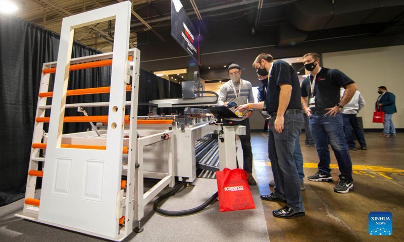 People look at a door cutting CNC machine during the 2021 WinDoor event in Toronto, Canada, on Nov. 17, 2021. Showcasing the window and door industry in Canada, the two-day event kicked off here on Wednesday.(Photo:Xinhua)