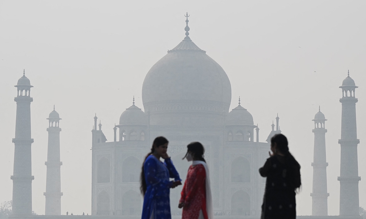 People visit the Mehtab Bagh complex behind the Taj Mahal amid smoggy conditions in Agra, India, on Tuesday. Photo: AFP