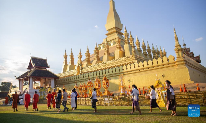 People pray around the That Luang Stupa in Vientiane, Laos, Nov. 18, 2021. The That Luang Festival, the most important religious festival in Laos, was observed by Lao people from all over the country around the That Luang Stupa. (Photo by Kaikeo Saiyasane/Xinhua)