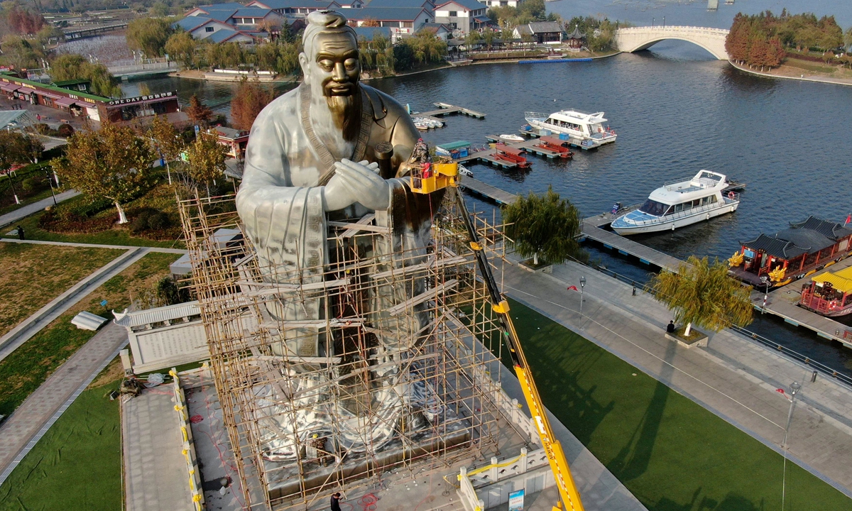 Workers paint an eight-story high statue of Confucius (551BC-479 BC) in Qingdao, East China's Shandong Province on November 18, 2021. Shandong is the birthplace of the ancient Chinese philosopher and educator. Photo: VCG