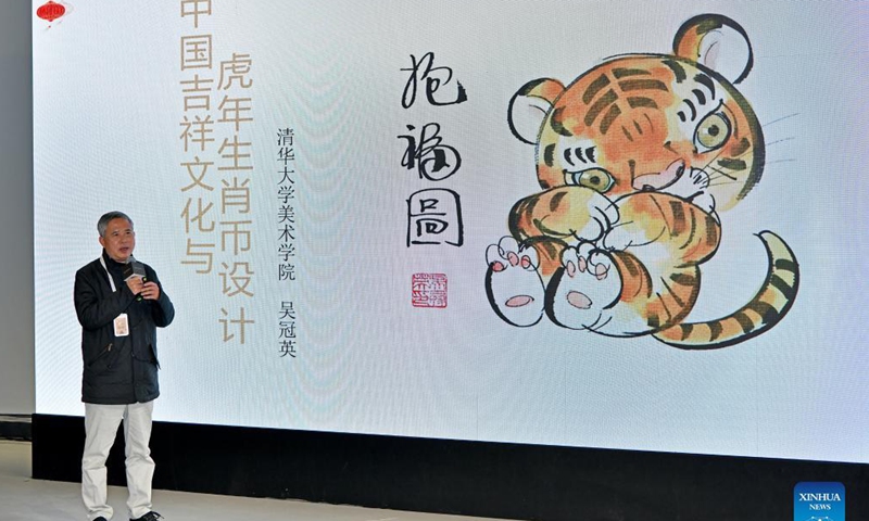 Wu Guanying, one of the designers of the reverse of the commemorative coins to celebrate the Chinese zodiac Year of the Tiger, also professor of Academy of Arts & Design in Tsinghua University, introduces the design of the commemorative coins in Beijing, capital of China, Nov. 18, 2021. Photo: Xinhua