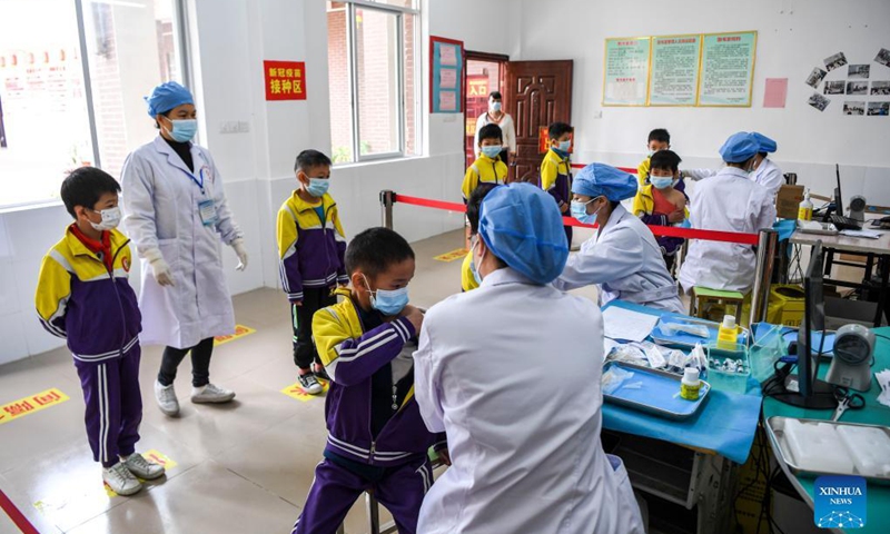Pupils line up to get inoculated with the COVID-19 vaccines at Weiming elementary school in Weiming Village, Shinan Township, Xingye County, south China's Guangxi Zhuang Autonomous Region, Nov. 18, 2021. Photo: Xinhua
