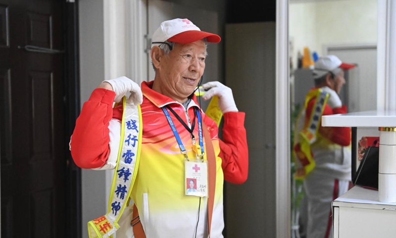 Octogenarian Ma Jinming puts on an uniform prepared by himself as he sets off to direct traffic voluntarily in Taiyuan, capital of north China's Shanxi Province, Nov. 17, 2021. Ma Jinming, 80, has kept up voluntarily directing traffic on the street for eleven years. Photo: Xinhua