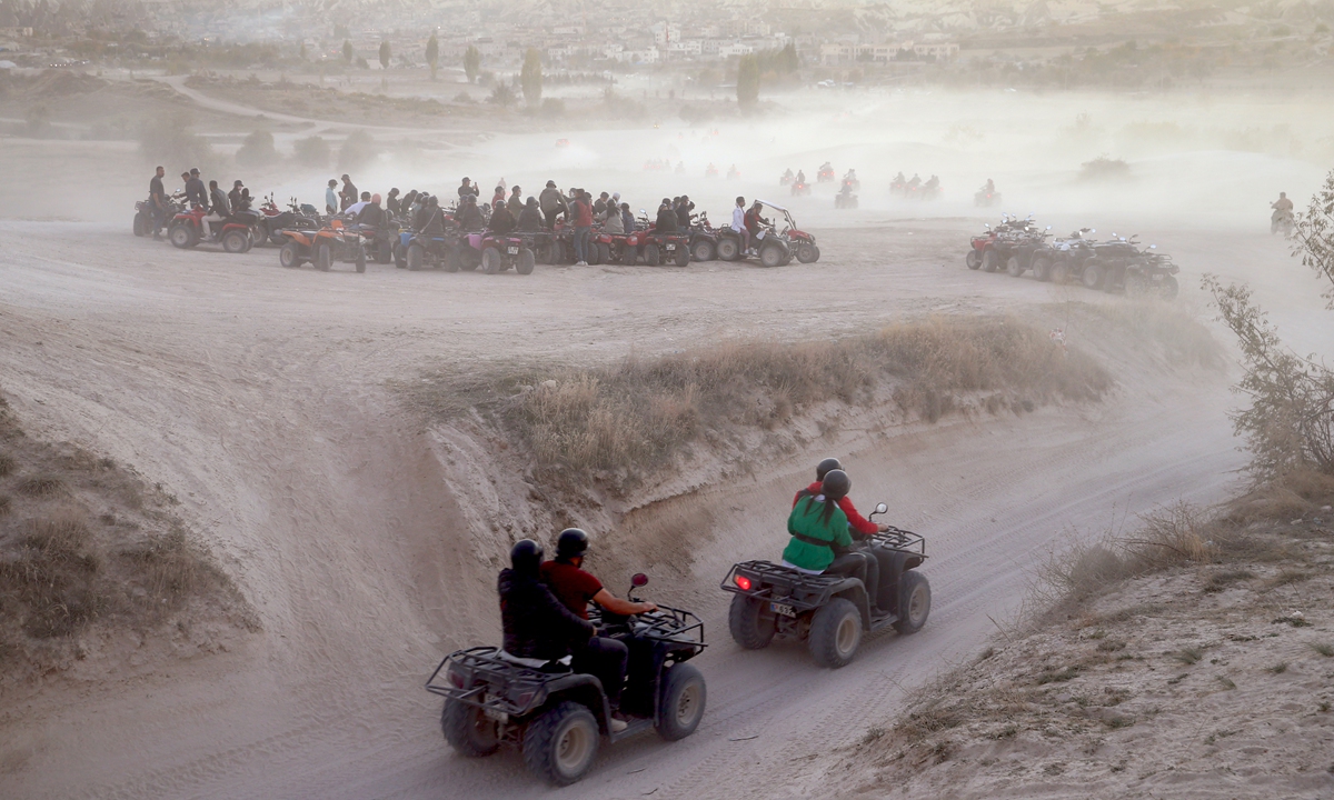 Tourists ride ATVs (all-terrain vehicle) while touring the chimney rocks at Gulludere Valley at the historical Cappadocia region on October 24.  Photo: VCG