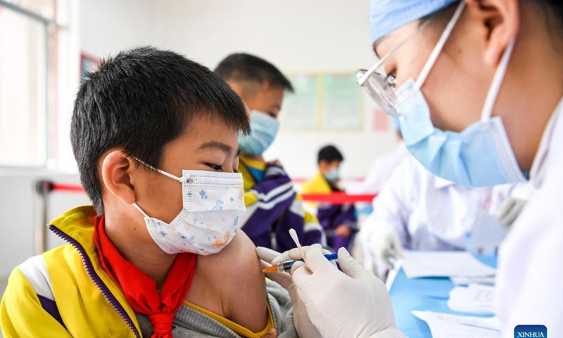 Pupils line up to get inoculated with the COVID-19 vaccines at Weiming elementary school in Weiming Village, Shinan Township, Xingye County, south China's Guangxi Zhuang Autonomous Region, Nov. 18, 2021. Photo: Xinhua