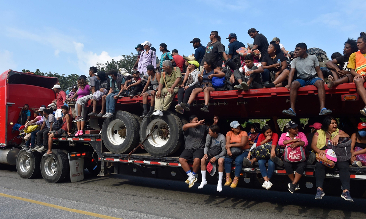 Migrants seeking for refugee status ride on the bed of a trailer in Jesus Carranza, in the Mexican state of Veracruz on November 17, 2021. A group of mainly Central American migrants are attempting to reach the US-Mexico border. Photo: AFP