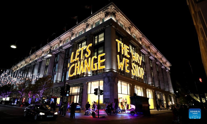 Photo take on Nov. 21, 2021 shows a building with light writing LET'S CHANGE THE WAY WE SHOP in central London, Britain. (Xinhua)