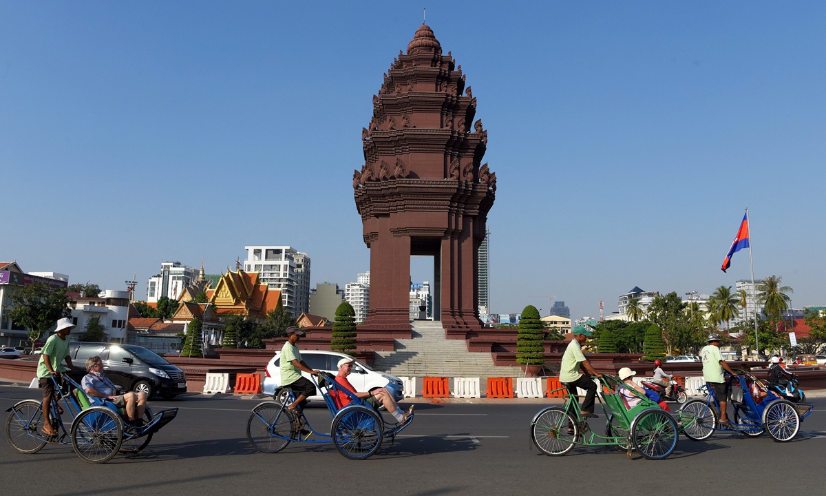 Tourists ride on cyclos pass the Independence Monument in Phnom Penh, Cambodia. Photo: AFP