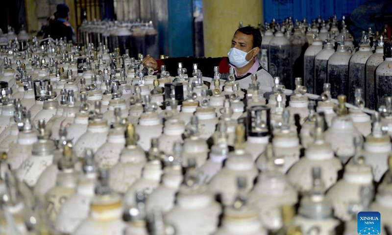 A worker installs the oxygen cylinders connected to the ward at a hospital in Jammu, the winter capital of Indian-controlled Kashmir, Nov. 18, 2021. (Str/Xinhua)