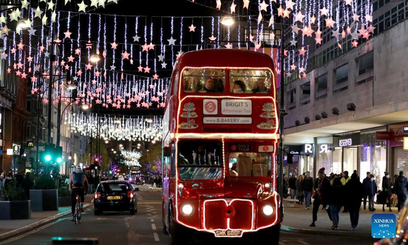 A double-decker bus runs on Oxford Street decorated with Christmas lights in central London, Britain, on Nov. 21, 2021. (Xinhua)