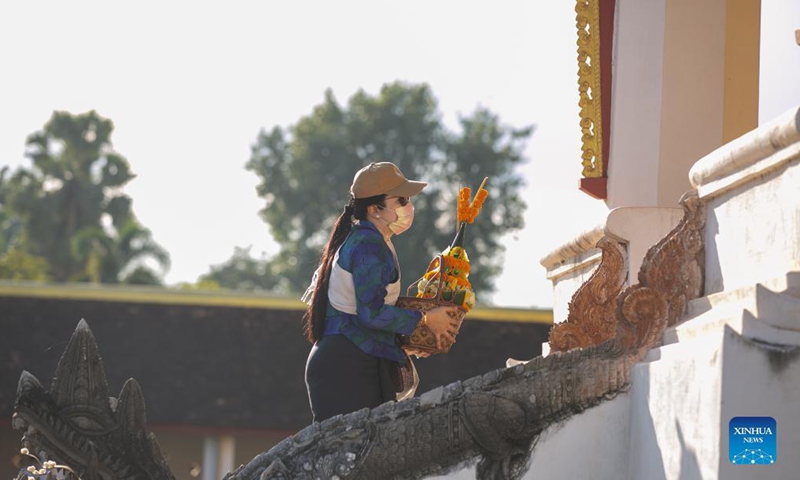 A woman prays at the That Luang Stupa in Vientiane, Laos, Nov. 18, 2021. The That Luang Festival, the most important religious festival in Laos, was observed by Lao people from all over the country around the That Luang Stupa. (Photo by Kaikeo Saiyasane/Xinhua)