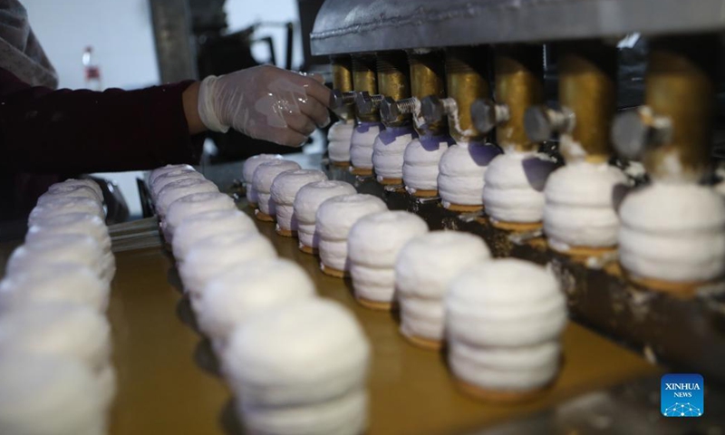A Palestinian worker makes chocolate Ras el-Abd at a sweet factory in the West Bank city of Hebron, Nov. 18, 2021. Ras el-Abd is a traditional candy covered with chocolate.(Photo by Mamoun Wazwaz/Xinhua) 