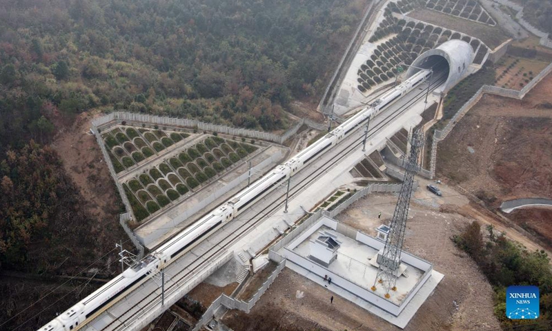 Aerial photo shows a train running in the Anqing-Huangmei section of the Anqing-Jiujiang high-speed railway in Anqing, east China's Anhui Province, Nov 19, 2021. The trial operation of the Anqing-Huangmei section of the Anqing-Jiujiang high-speed railway began on Friday.Photo:Xinhua