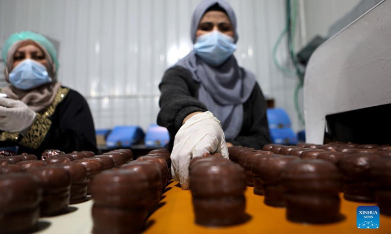 Palestinian workers make chocolate Ras el-Abd at a sweet factory in the West Bank city of Hebron, Nov. 18, 2021. Ras el-Abd is a traditional candy covered with chocolate. (Photo by Mamoun Wazwaz/Xinhua) 