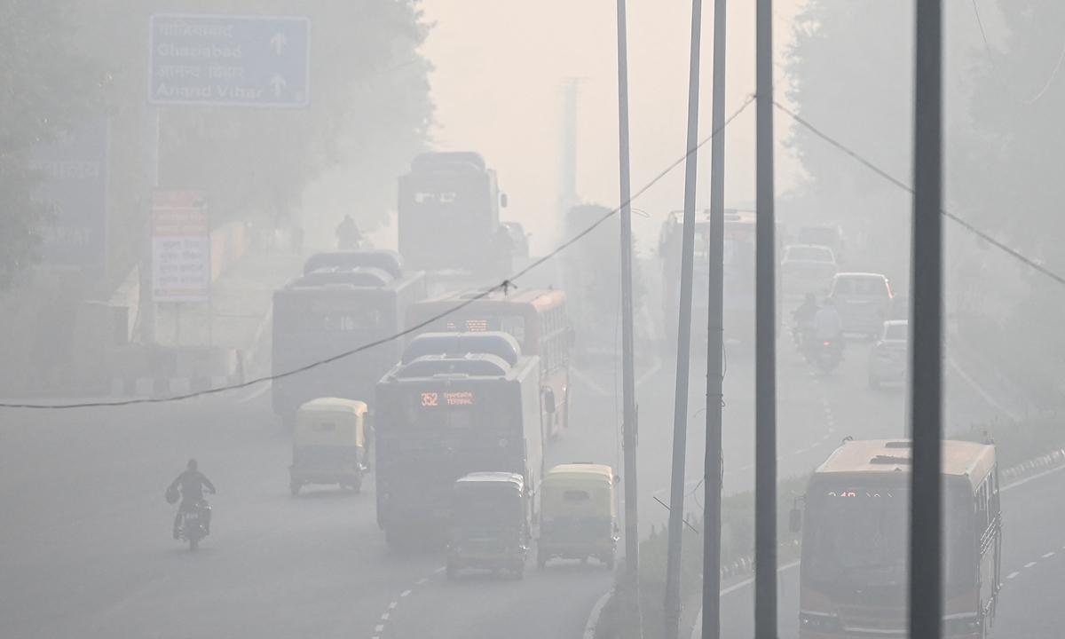 Commuters drive along a road amid heavy smog conditions in New Delhi, India on November 21, 2021. Photo: AFP