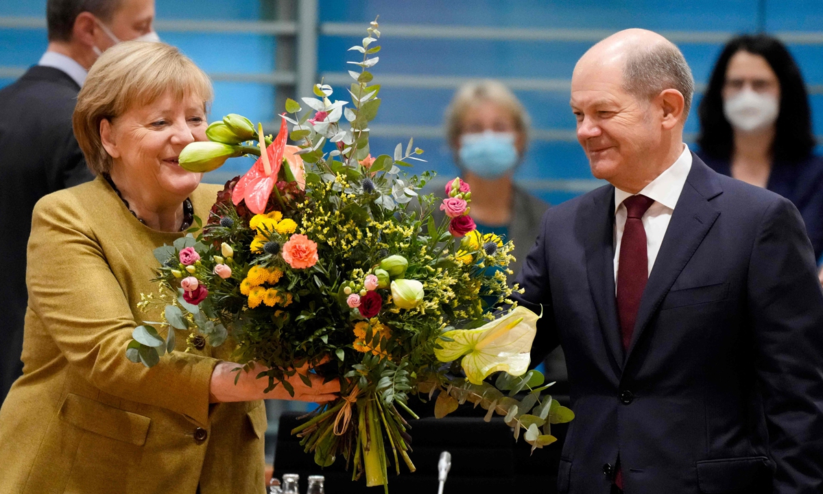 German Chancellor Angela Merkel receives a bouquet of flowers from Vice Chancellor and Finance Minister Olaf Scholz before the cabinet meeting in Berlin on November 24, 2021. Due to the schedule of coalition talks for a new German government, it is probably Merkel's last cabinet session as German Chancellor, after a historic 16 years in power. Photo: VCG 