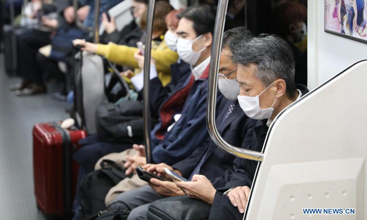 People wearing face masks sit in a train in Tokyo, Japan, on November 12. Photo: Xinhua