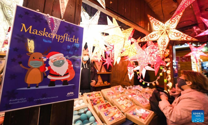 A sign notifying customers to wear face masks is seen at the Frankfurt Christmas Market in Frankfurt, Germany, Nov. 22, 2021.Photo:Xinhua