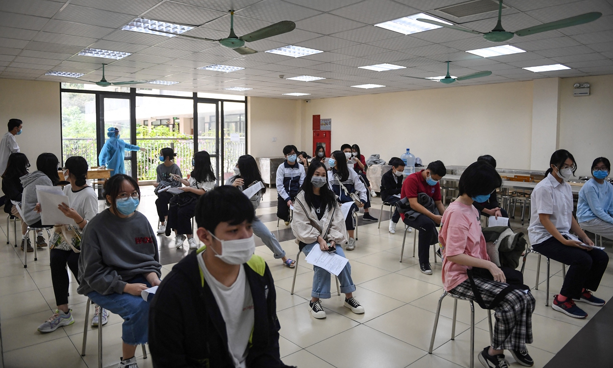 Youths between the age of 12 to 17 wait to receive the Pfizer/BioNTech COVID-19 vaccine in Hanoi, Vietnam on Tuesday. Vietnam reported more than 10,000 new infections on Tuesday, bringing the total number of COVID-19 cases to 1.1 million, with about 24,000 deaths. Photo: AFP
