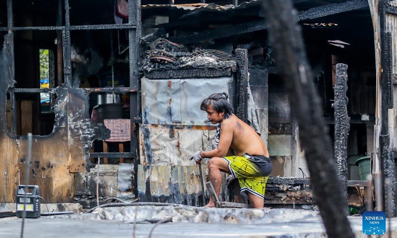 Residents search for their belongings in their charred homes after a fire at a residential area in Quezon City, the Philippines, Nov. 23, 2021. The fire took place on Monday, leaving 120 shanties razed. Photo: Xinhua