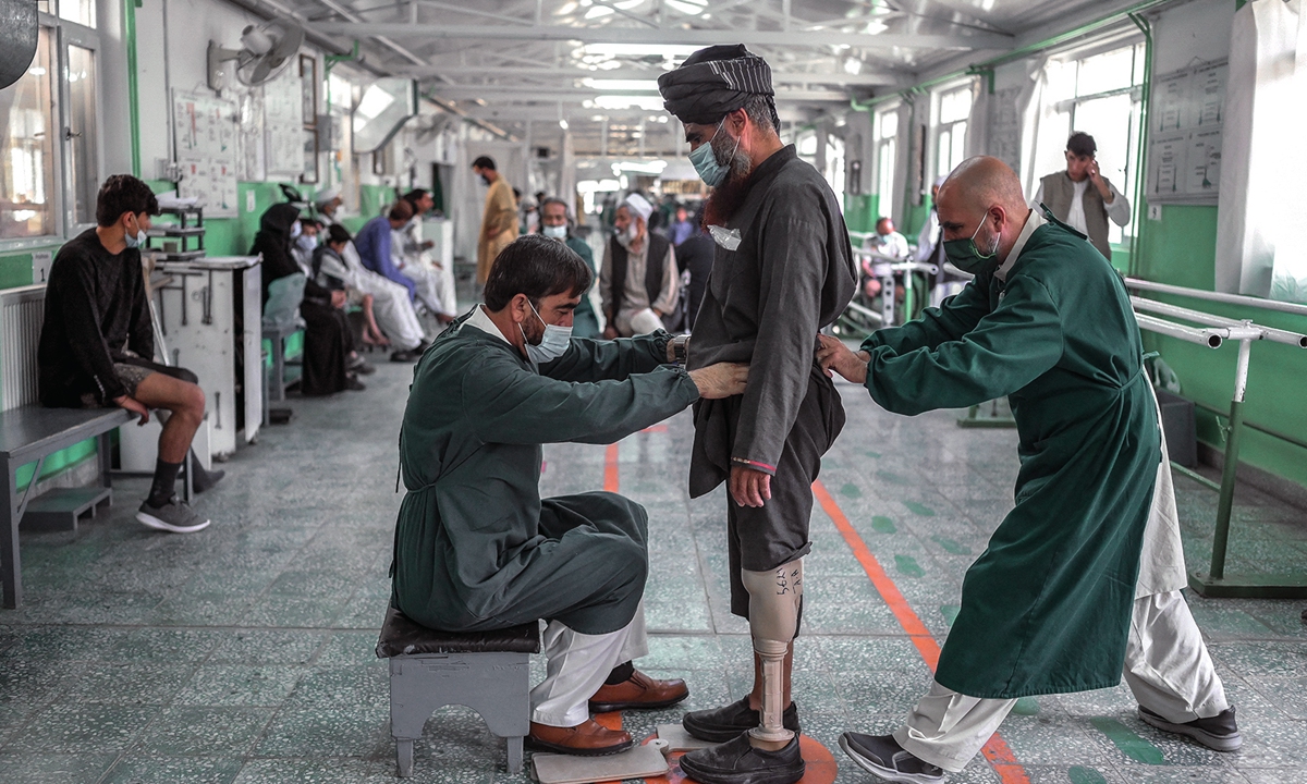 Members of International Committee of Red Cross Rehabilitation centre helps a Taliban member, who claims to have lost his leg earlier during a US forces strike, in Kabul on October 11, 2021. Photo: AFP