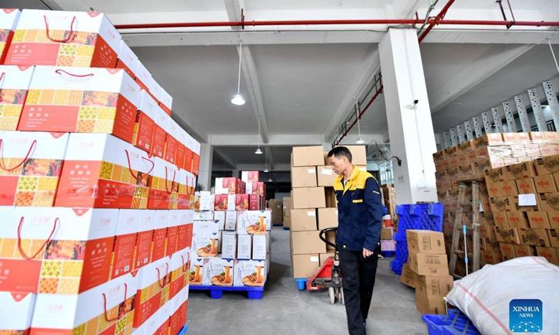 A worker conveys packed Luosifen rice noodles at a food-processing company in Liuzhou, south China's Guangxi Zhuang Autonomous Region, Nov. 23, 2021.Photo:Xinhua