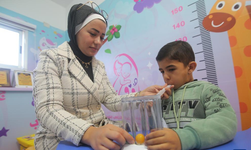 A Palestinian therapist interacts with a child at a local center for speech therapy and language rehabilitation in the southern Gaza Strip city of Rafah, Nov. 23, 2021.Photo:Xinhua