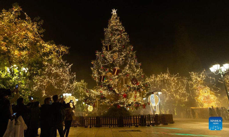 People take photos of illuminated trees with decorative lights in Syntagma Square in Athens, Greece, on Nov. 23, 2021.Photo:Xinhua