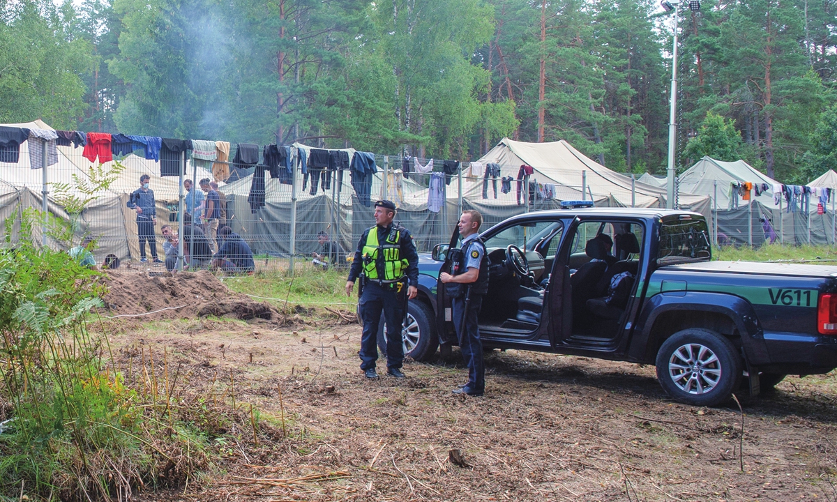 Lithuanian law enforcement officers guard outside a tent camp for migrants detained of illegal border crossing in Alytus near the border with Belarus on August 13, 2021. Photo: VCG