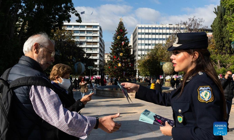 A policewoman gives leaflets to passersby on the International Day for the Elimination of Violence against Women in Athens, Greece, Nov. 25, 2021.Photo:Xinhua