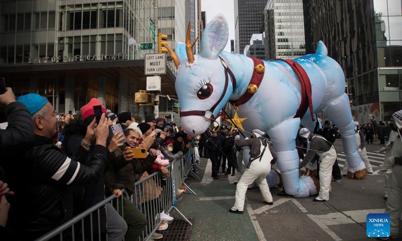 An inflated animal interacts with revelers during the Macy's Thanksgiving Day Parade in New York, the United States, Nov 25, 2021.Photo:Xinhua