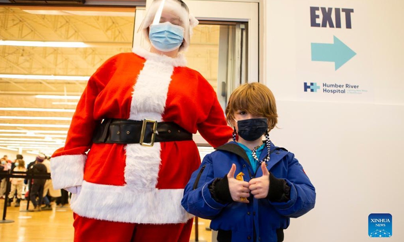 A child poses for photos with a woman dressed as Santa Claus after being vaccinated at a vaccination clinic in Toronto, Canada, on Nov 25, 2021. The city of Toronto on Thursday began COVID-19 vaccination for children aged 5 to 11 who have confirmed appointments.Photo:Xinhua