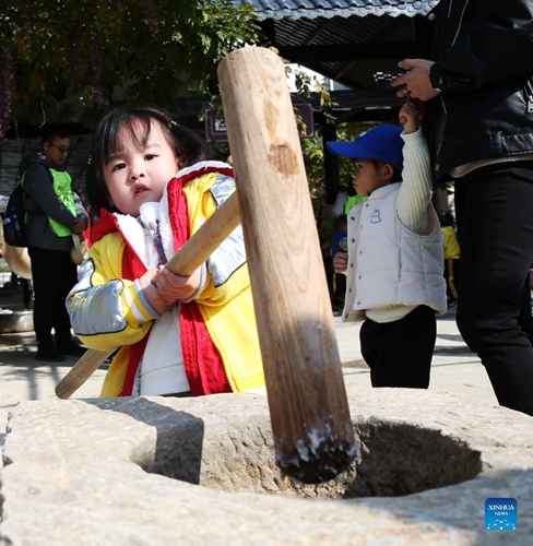 Photo taken on Nov. 27, 2021 shows children using a pestle and mortar at Zhaizi Farming Experience Centre in Qianjiang, southwest China's Chongqing Municipality.Photo:Xinhua