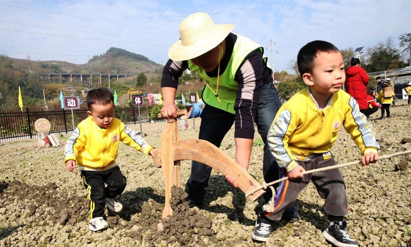 Photo taken on Nov. 27, 2021 shows children tilling the soil at Zhaizi Farming Experience Centre in Qianjiang District, southwest China's Chongqing Municipality.Photo:Xinhua