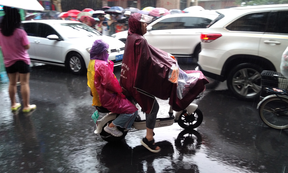A parent picks up his child in Zhengzhou, Central China's Henan Province in heavy rain on July 2, 2021. Photo: CFP