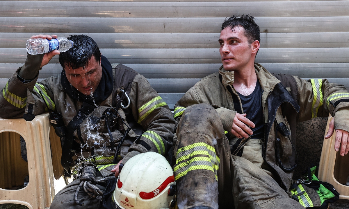 Firefighters put out a fire that broke out at a workplace in the Fatih district in Istanbul, Turkey on June 28. Exhausted firefighters catch their breath after putting out a fire that broke out at a workplace in the Fatih district in Istanbul, Turkey on June 28. Photos: VCG