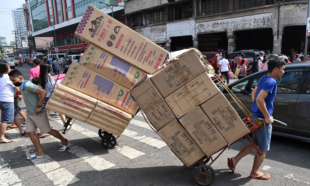 Workers pull carts loaded with goods for delivery in the Divisoria district of Manila, the Philippines on November 30, 2021. Despite the threat of the Omicron variant of COVID-19, the Philippine Radio Television Malacanang on Tuesday said it is confident that the Philippines could still achieve its target of 4 to 5 percent economic growth by the end of 2021. Photo: AFP