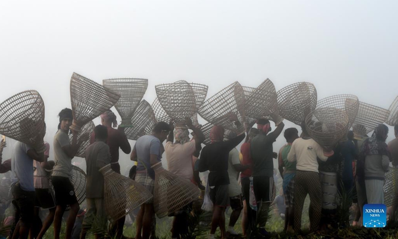 People with polos (traditional bamboo fish traps) in hand go for traditional fish hunting at a marshy land in Pabna, Bangladesh on Nov. 27, 2021.(Photo: Xinhua)