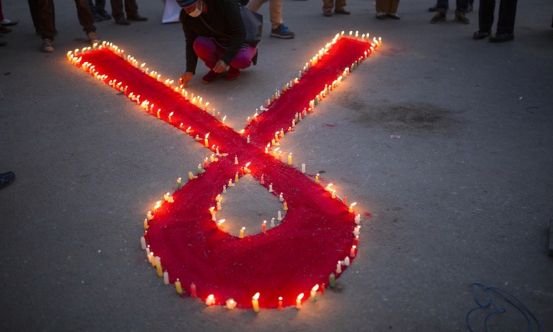 A volunteer lights candles during an AIDS awareness campaign on the eve of World AIDS Day in Kathmandu, Nepal, Nov. 30, 2021.(Photo: Xinhua)