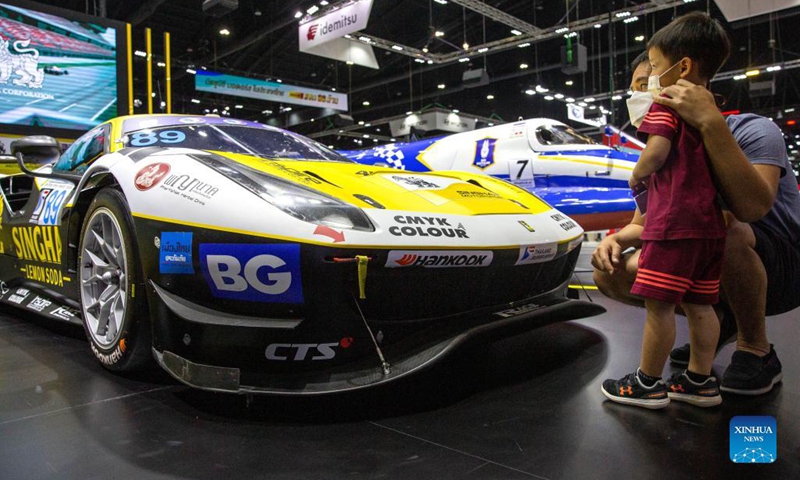 Visitors view a Ferrari car during the Thailand International Motor Expo 2021 in Bangkok, Thailand, Dec. 1, 2021. The Motor Expo kicked off on Dec. 1 and will last until Dec. 12, showcasing 32 car brands and 12 motorcycle brands as well as electric vehicles.(Photo: Xinhua)