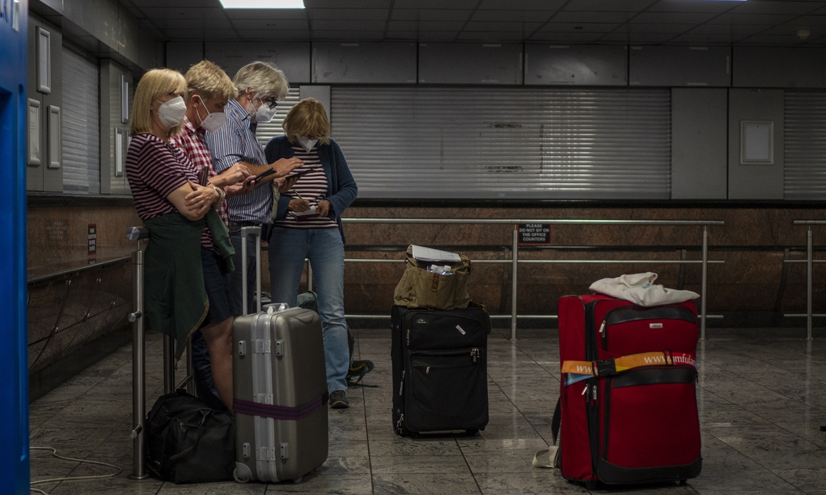 Passengers check their phones at Johannesburg's O.R. Tambo International Airport on November 29, 2021. Photo: AFP